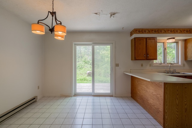 48 Pine Hill Dr Unit 48, Bath, ME 04530 - kitchen with baseboard heating, a sink, brown cabinetry, healthy amount of natural light, and a textured ceiling