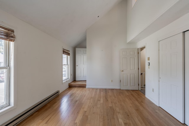 48 Pine Hill Dr Unit 48, Bath, ME 04530 - unfurnished room featuring a baseboard radiator, light wood-type flooring, high vaulted ceiling, and baseboards