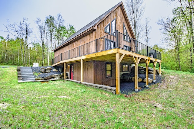 rear view of house with a wooden deck and a yard