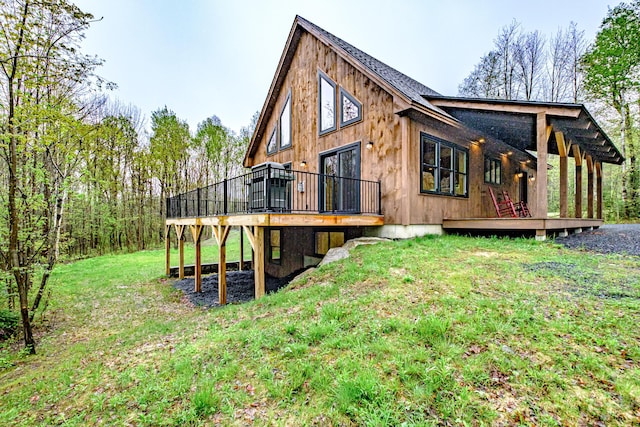 back of property with a wooden deck and a lawn