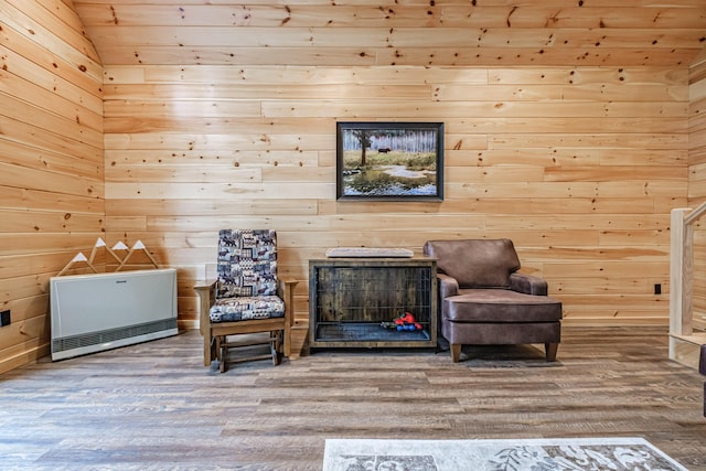 living area featuring wood finished floors, wooden walls, heating unit, and wood ceiling