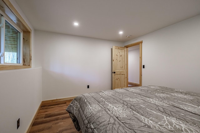 bedroom featuring wood finished floors, recessed lighting, and baseboards