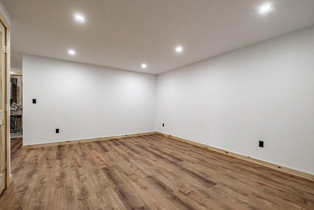 spare room with wood finished floors, recessed lighting, and baseboards