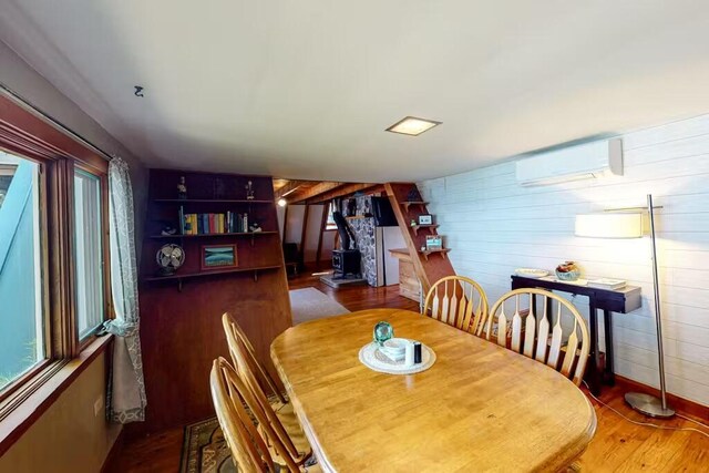 352 Georges Pond Rd, Franklin, ME 04634 - dining space with an AC wall unit, plenty of natural light, wood finished floors, and wooden walls