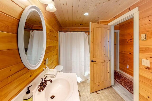 352 Georges Pond Rd, Franklin, ME 04634 - bathroom featuring a sink, wood ceiling, wood finished floors, wooden walls, and recessed lighting