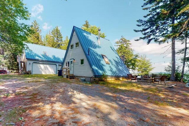 352 Georges Pond Rd, Franklin, ME 04634 - view of home's exterior featuring a garage, metal roof, entry steps, and a standing seam roof