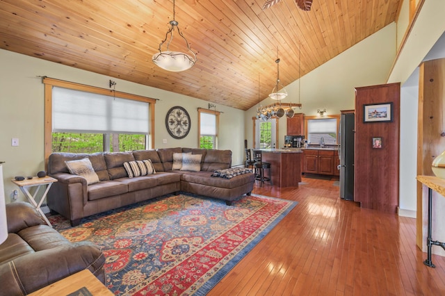 living area featuring hardwood / wood-style floors, high vaulted ceiling, wooden ceiling, and a chandelier