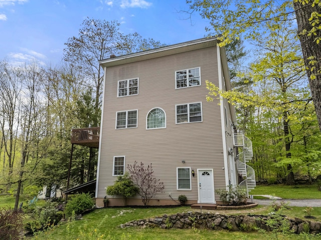 back of house with a yard and stairway