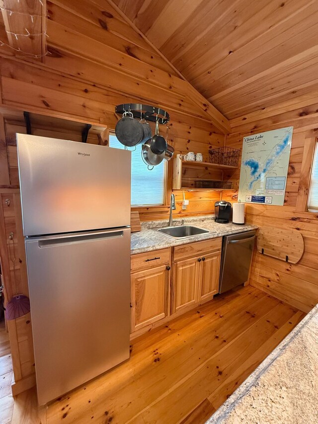 1270 Lakeview Dr Unit 21, China, ME 04358 - kitchen featuring stainless steel appliances, a sink, light wood-style floors, vaulted ceiling, and wood walls