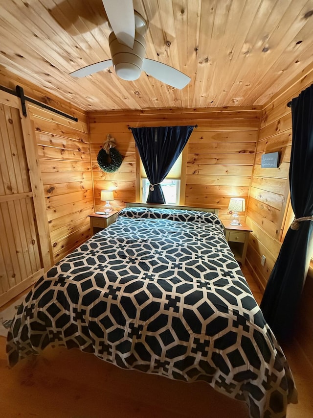 1270 Lakeview Dr Unit 21, China, ME 04358 - bedroom featuring wooden ceiling, a barn door, wood walls, a ceiling fan, and wood finished floors