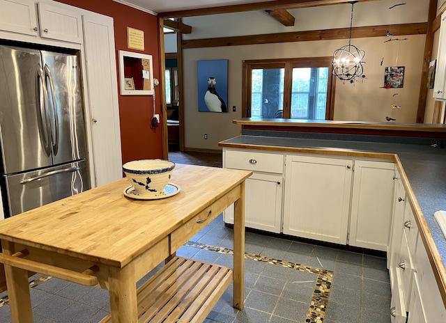 15 Miles Rd, Tremont, ME 04674 - kitchen featuring freestanding refrigerator, dark countertops, white cabinets, a peninsula, and decorative light fixtures