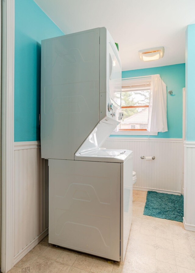 160 Rattlesnake Rd, Brownfield, ME 04010 - clothes washing area featuring stacked washer and clothes dryer and a wainscoted wall
