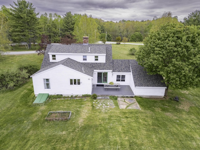 7 Salmon Run, Raymond, ME 04071 - back of property featuring roof with shingles, a chimney, a wooden deck, a lawn, and a wooded view