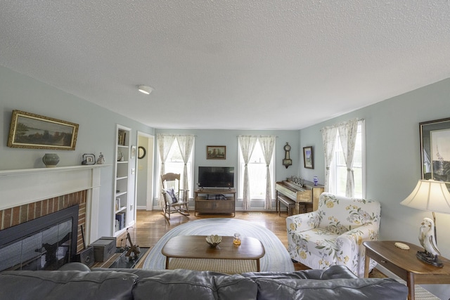7 Salmon Run, Raymond, ME 04071 - living area with a textured ceiling, wood finished floors, a fireplace, and built in features