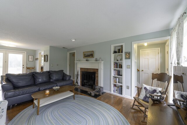7 Salmon Run, Raymond, ME 04071 - living area with wood finished floors, built in shelves, a fireplace, and baseboards