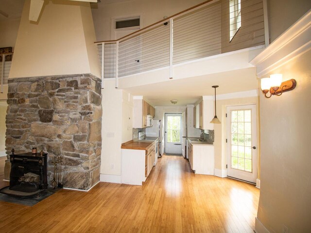 9 Juniper Ln, Damariscotta, ME 04543 - kitchen with a sink, a towering ceiling, light wood-type flooring, electric range, and a wood stove