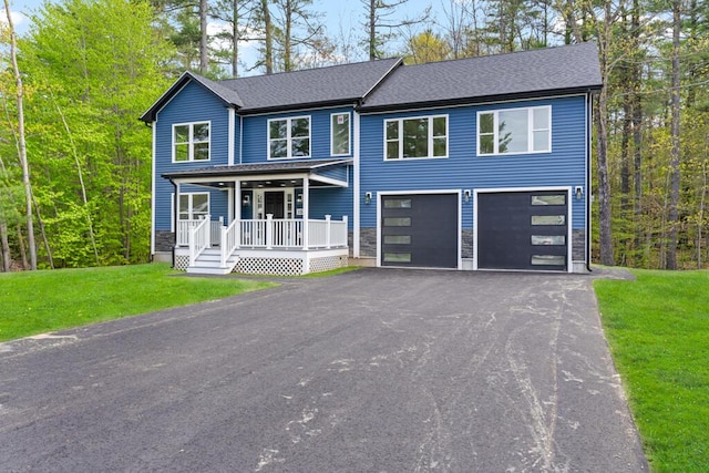 15 Stone Ledge Dr, Lewiston, ME 04240 - view of front facade featuring covered porch, driveway, an attached garage, a front yard, and roof with shingles