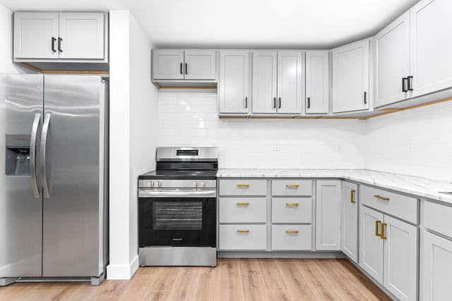 15 Stone Ledge Dr, Lewiston, ME 04240 - kitchen with stainless steel appliances, gray cabinetry, light wood-style floors, backsplash, and light stone countertops