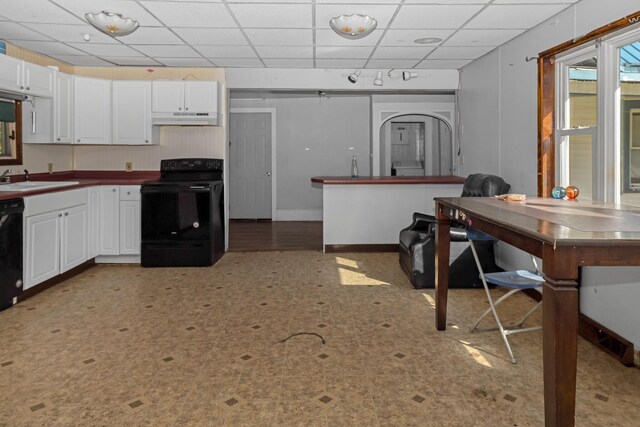 501 Knox St, Rumford, ME 04276 - kitchen with black appliances, under cabinet range hood, white cabinetry, a sink, and a paneled ceiling