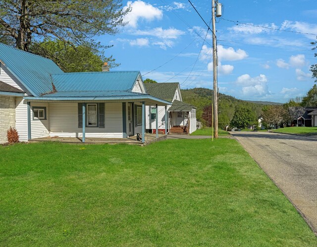 501 Knox St, Rumford, ME 04276 - view of front of property with a front lawn, a porch, metal roof, and a chimney