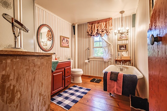 321 Clarks Bridge Rd, Waterboro, ME 04061 - bathroom with wood-type flooring, a freestanding tub, toilet, vanity, and baseboards