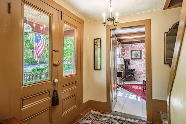 321 Clarks Bridge Rd, Waterboro, ME 04061 - doorway to outside with a wood stove, baseboards, a chandelier, and wallpapered walls