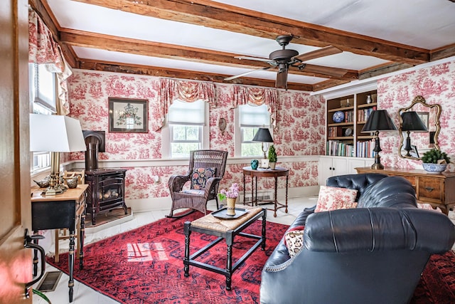 321 Clarks Bridge Rd, Waterboro, ME 04061 - living room with wallpapered walls, a ceiling fan, a wood stove, beamed ceiling, and baseboards
