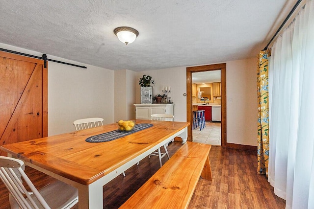 286 Canaan Rd, Clinton, ME 04927 - dining space with a barn door, wood finished floors, and baseboards