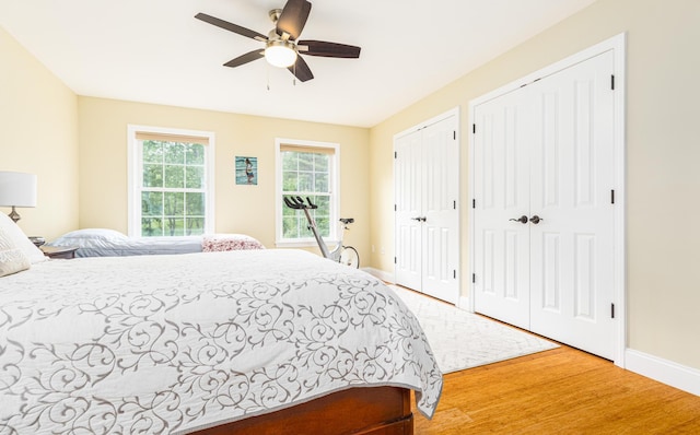 239 Cider Hill Rd, York, ME 03909 - bedroom with two closets, baseboards, wood finished floors, and ceiling fan