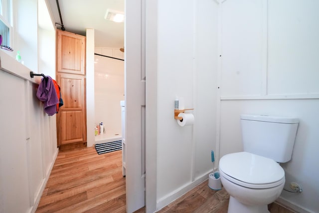 486 Main St, Orono, ME 04473 - bathroom featuring wood finished floors, a shower, toilet, and baseboards