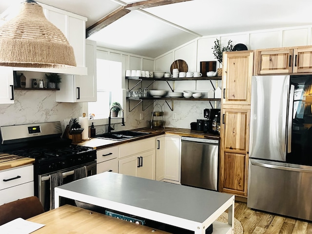 486 Main St, Orono, ME 04473 - kitchen with appliances with stainless steel finishes, open shelves, a sink, vaulted ceiling, and backsplash