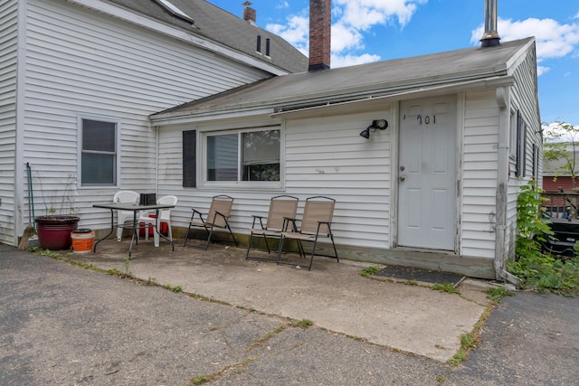 138 Summer St, Biddeford, ME 04005 - rear view of property with a patio, a chimney, and roof with shingles