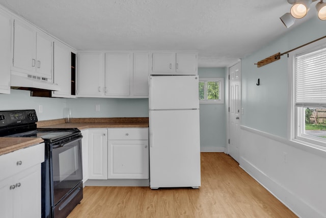 138 Summer St, Biddeford, ME 04005 - kitchen featuring freestanding refrigerator, black electric range, under cabinet range hood, light wood-type flooring, and white cabinets