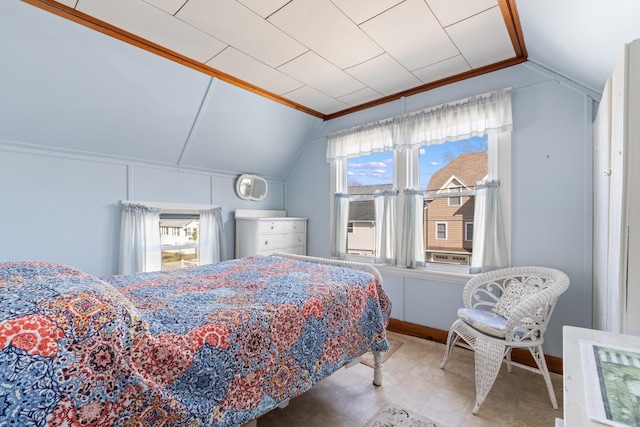 bedroom featuring lofted ceiling and baseboards