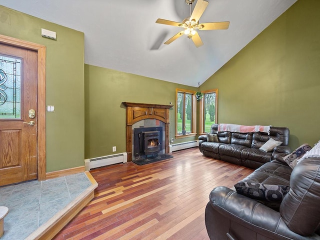 19 Falls Rd, Benton, ME 04901 - living area featuring a baseboard radiator, a wood stove, hardwood / wood-style flooring, a ceiling fan, and vaulted ceiling