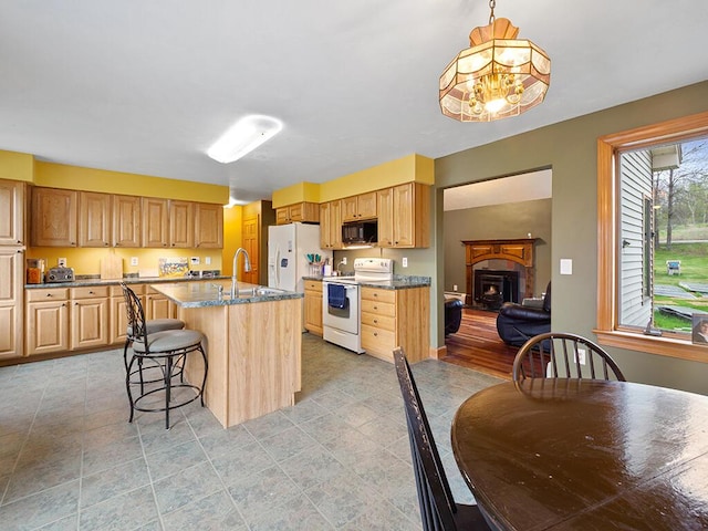 19 Falls Rd, Benton, ME 04901 - kitchen featuring white appliances, a sink, a kitchen bar, a center island with sink, and decorative light fixtures
