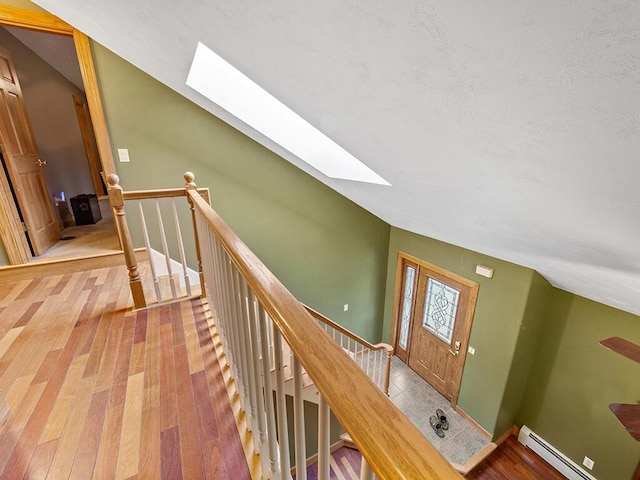 19 Falls Rd, Benton, ME 04901 - corridor with a skylight, an upstairs landing, baseboard heating, lofted ceiling, and wood finished floors