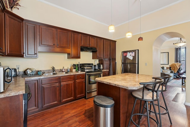 450 Cumberland Ave, Portland, ME 04101 - kitchen with appliances with stainless steel finishes, a sink, under cabinet range hood, arched walkways, and dark wood finished floors