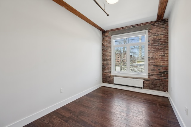 2 Main St Unit 35-203, Biddeford, ME 04005 - unfurnished room featuring radiator heating unit, baseboards, dark wood-type flooring, and brick wall