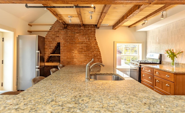 32 Pleasant St Unit 3, Portland, ME 04101 - kitchen with a sink, stainless steel appliances, brown cabinets, light stone countertops, and brick wall