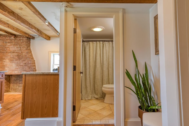 32 Pleasant St Unit 3, Portland, ME 04101 - bathroom with toilet, beam ceiling, and brick wall