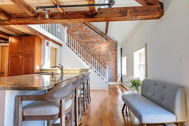 32 Pleasant St Unit 3, Portland, ME 04101 - dining space featuring light wood-type flooring, stairway, brick wall, beamed ceiling, and baseboards