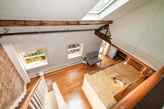 32 Pleasant St Unit 3, Portland, ME 04101 - unfurnished living room with a skylight, a baseboard heating unit, and wood finished floors