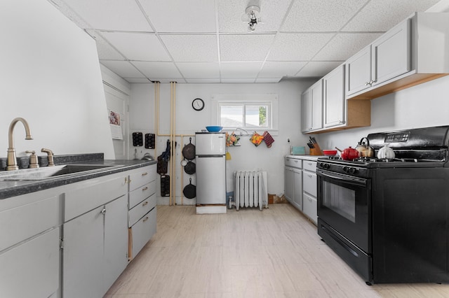103 Green St, Augusta, ME 04330 - kitchen with radiator heating unit, black range with gas cooktop, a sink, refrigerator, and a drop ceiling