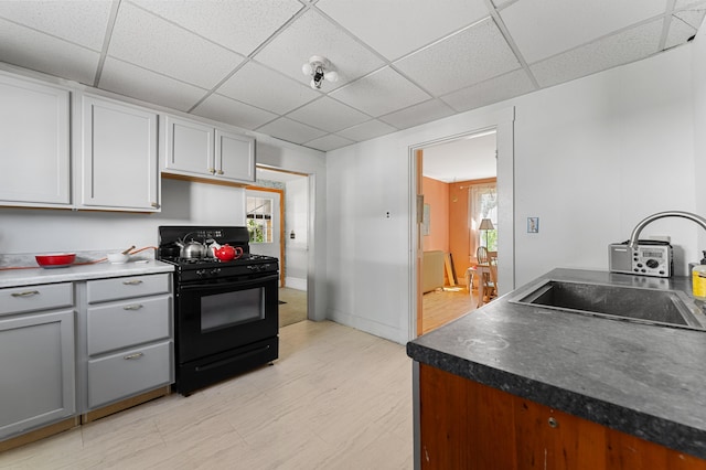 103 Green St, Augusta, ME 04330 - kitchen with black range with gas cooktop, a paneled ceiling, a sink, gray cabinets, and dark countertops