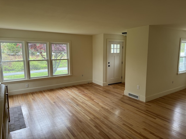 24 Chapel St, Boothbay, ME 04537 - unfurnished living room featuring baseboards, healthy amount of natural light, and light wood-type flooring