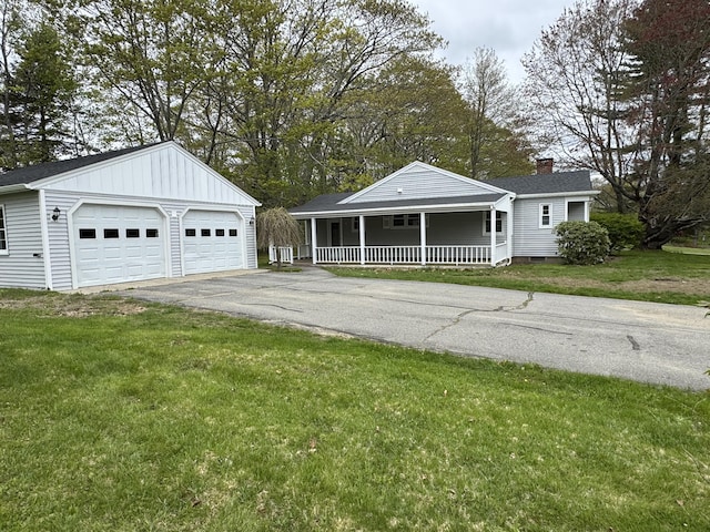 24 Chapel St, Boothbay, ME 04537 - view of front of home with a porch, a front yard, board and batten siding, a garage, and a chimney