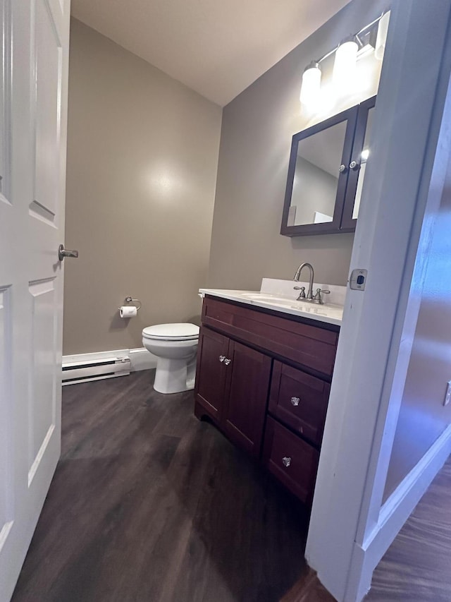 128 Fern St, Bangor, ME 04401 - bathroom featuring a baseboard heating unit, wood finished floors, toilet, baseboards, and vanity