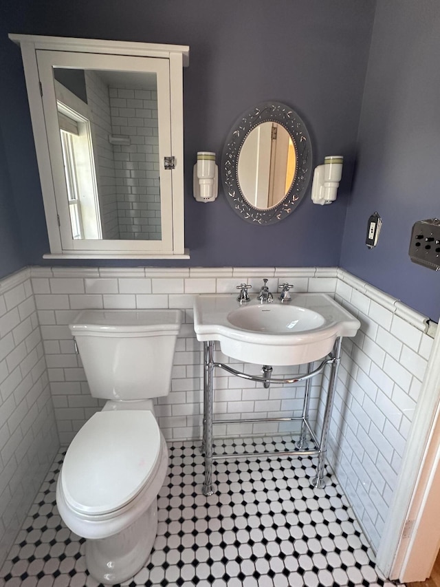 128 Fern St, Bangor, ME 04401 - bathroom featuring tile walls, a wainscoted wall, toilet, and tile patterned floors