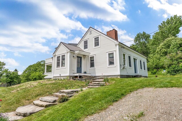 661 Veterans Hwy, Brooks, ME 04921 - view of front facade featuring a chimney, a metal roof, and a front lawn
